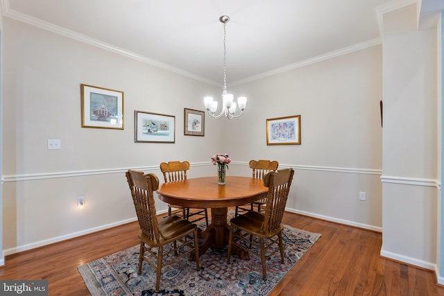 dining space featuring a chandelier, hardwood / wood-style floors, and ornamental molding