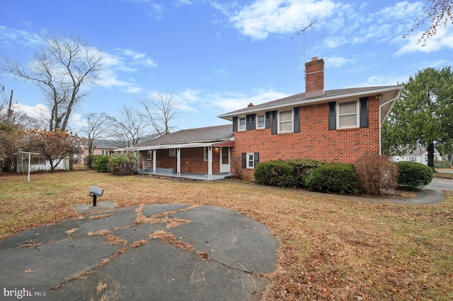 rear view of property featuring a lawn