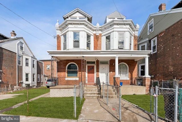 view of front facade with a front yard and covered porch