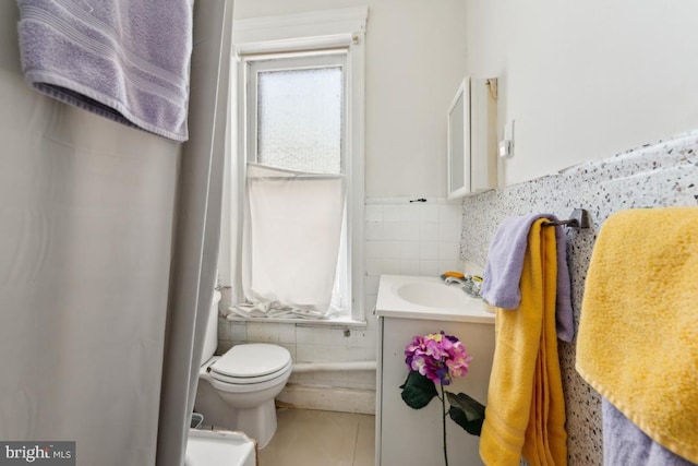 bathroom featuring tile walls, vanity, tile patterned floors, and toilet