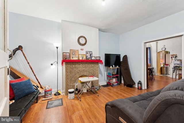 living room with hardwood / wood-style flooring and a brick fireplace