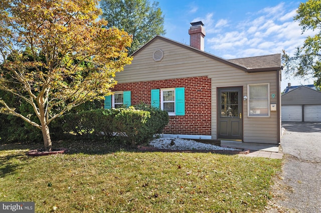 bungalow-style home with a garage, a front lawn, and an outdoor structure