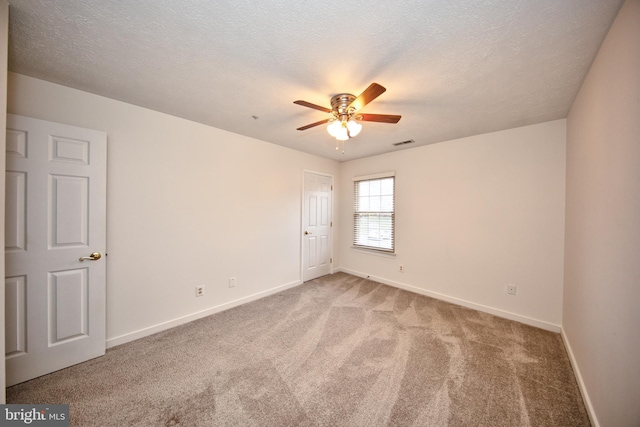 carpeted empty room featuring a textured ceiling and ceiling fan