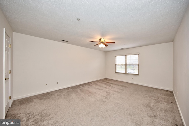 empty room with carpet flooring, ceiling fan, and a textured ceiling