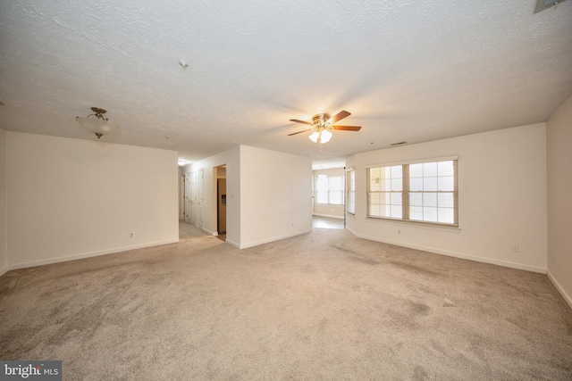 unfurnished room with a textured ceiling, light colored carpet, and ceiling fan