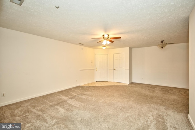 carpeted spare room with ceiling fan and a textured ceiling