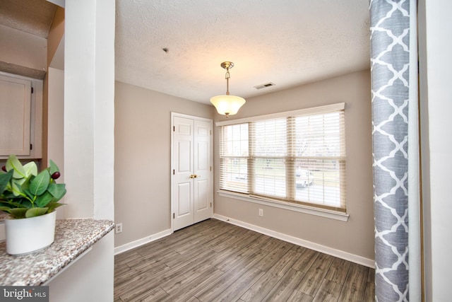 dining space featuring hardwood / wood-style floors and a textured ceiling