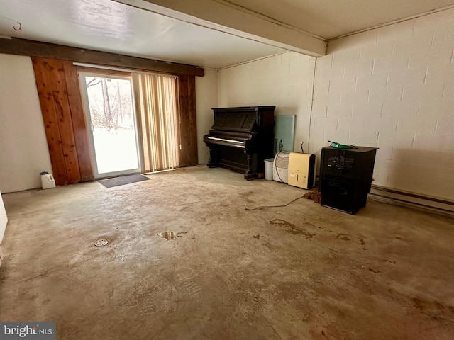 misc room with a baseboard heating unit and concrete floors