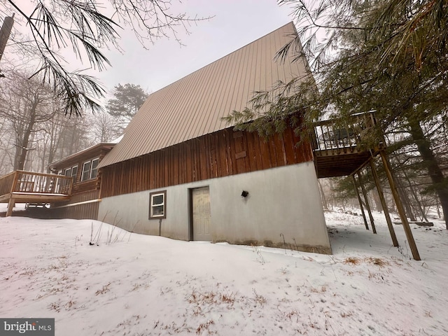 snow covered rear of property with a balcony