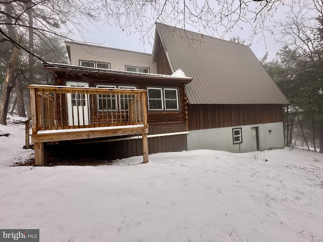 snow covered house featuring a deck