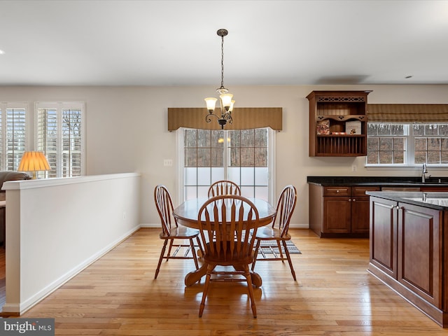 dining area featuring light hardwood / wood-style floors, sink, and a chandelier