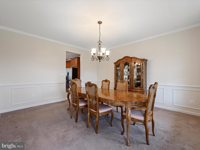 carpeted dining area featuring crown molding and a notable chandelier