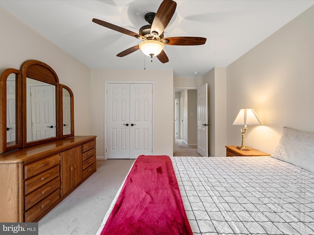 bedroom featuring ceiling fan, a closet, and light colored carpet