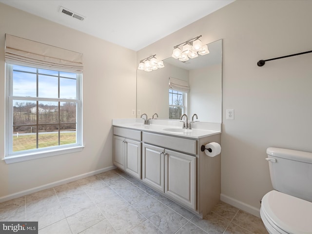 bathroom with vanity, toilet, and a wealth of natural light