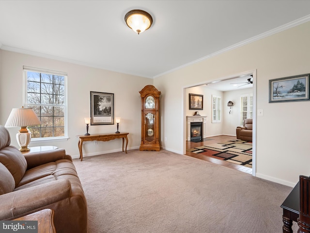 living room featuring ceiling fan, light colored carpet, and crown molding