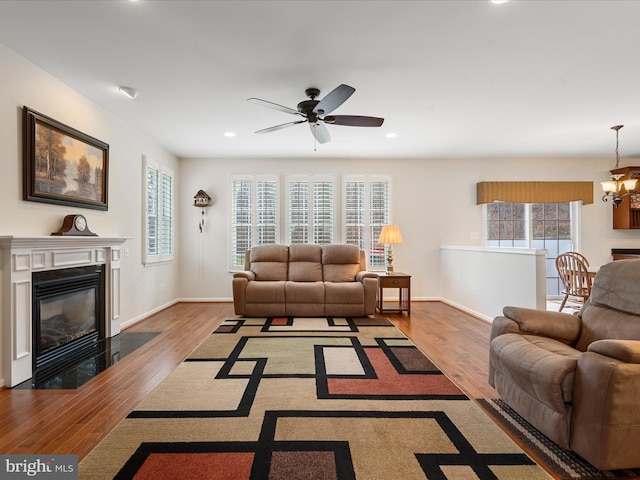 living room featuring plenty of natural light, light hardwood / wood-style floors, and ceiling fan with notable chandelier