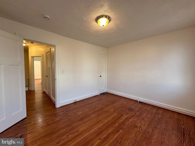 spare room with dark hardwood / wood-style flooring and a textured ceiling