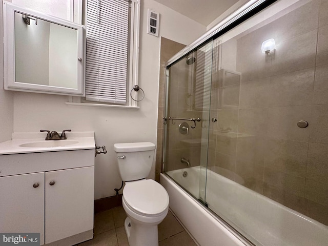 full bathroom with tile patterned flooring, vanity, toilet, and enclosed tub / shower combo