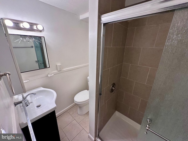 bathroom with vanity, toilet, tile patterned flooring, and walk in shower