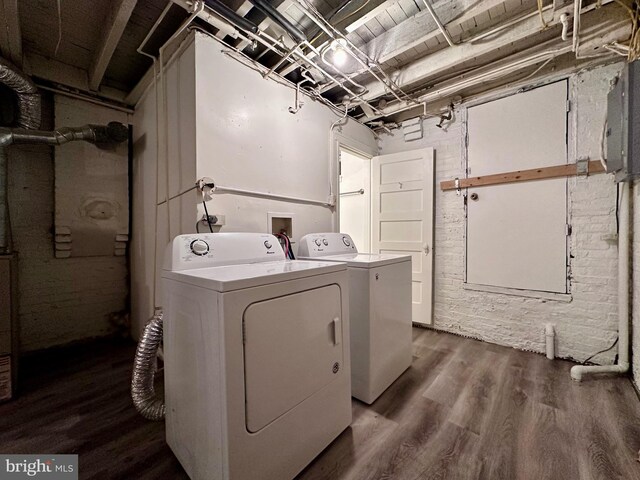 clothes washing area with washing machine and clothes dryer and hardwood / wood-style flooring