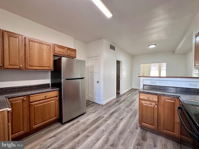 kitchen with stainless steel refrigerator, black electric range oven, and light hardwood / wood-style floors