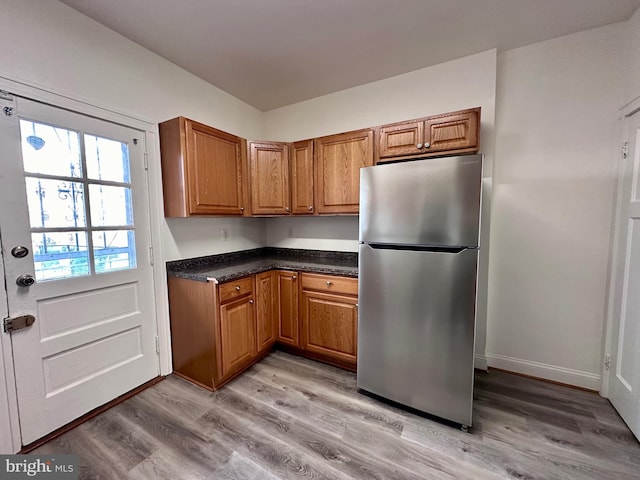 kitchen with light wood-type flooring and stainless steel refrigerator