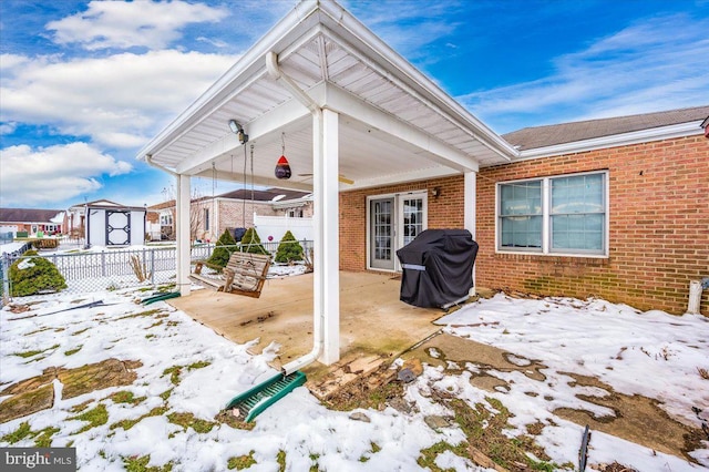 snow covered patio with area for grilling