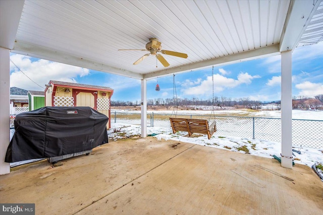 snow covered patio featuring grilling area and ceiling fan