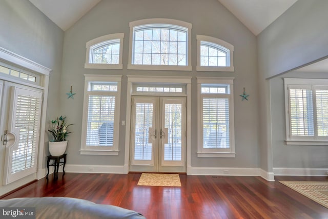 foyer entrance featuring dark hardwood / wood-style flooring, high vaulted ceiling, and french doors