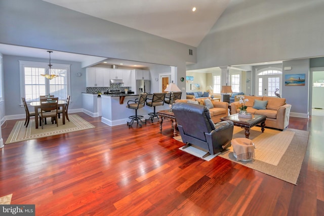 living room featuring french doors, high vaulted ceiling, and dark hardwood / wood-style floors