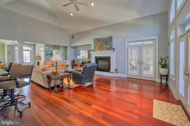 living room featuring ornate columns, ceiling fan, french doors, high vaulted ceiling, and hardwood / wood-style flooring