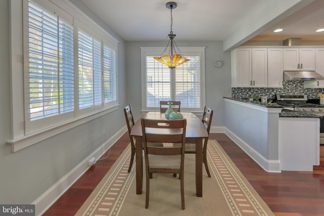 dining space with dark wood-type flooring and a healthy amount of sunlight