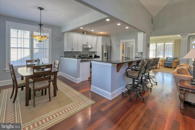 kitchen with stainless steel appliances, white cabinetry, plenty of natural light, and dark wood-type flooring