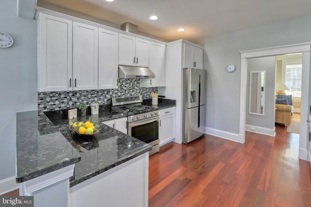 kitchen with white cabinets, stainless steel appliances, dark hardwood / wood-style floors, and dark stone counters