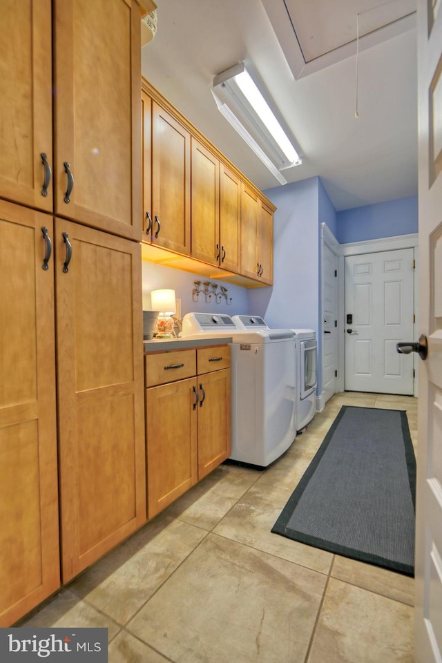 clothes washing area featuring cabinets and separate washer and dryer