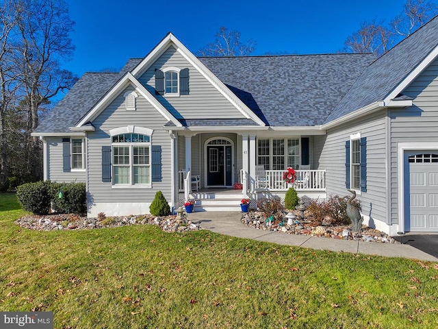 view of front of home with a garage, covered porch, and a front lawn