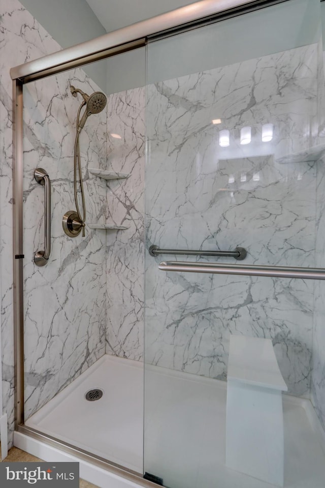 bathroom featuring a shower with shower door