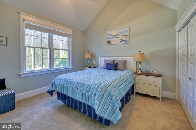 carpeted bedroom featuring a closet and vaulted ceiling