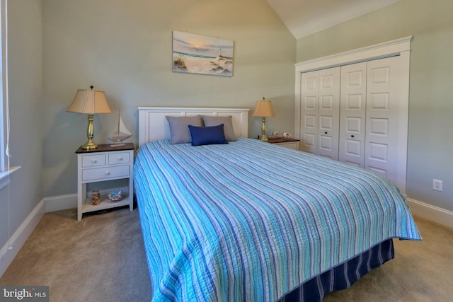 bedroom with carpet flooring, vaulted ceiling, and a closet