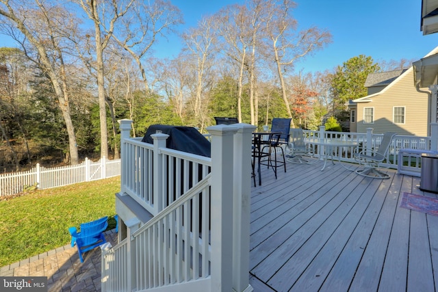 wooden terrace featuring a yard and an outdoor bar