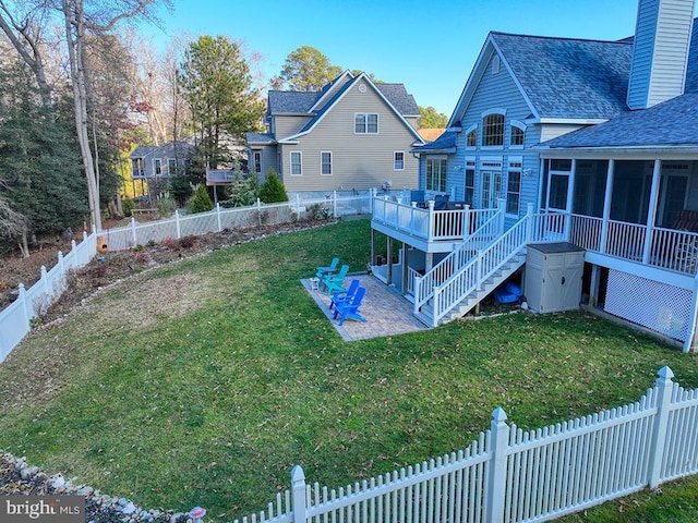 view of yard with a sunroom, a patio area, and a wooden deck