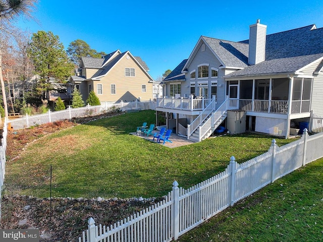 rear view of property with a sunroom, a yard, a patio, and a wooden deck