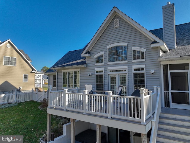 rear view of property with a lawn and a deck