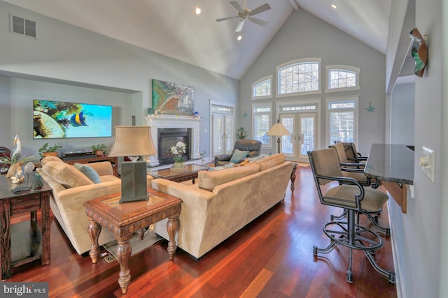 living room featuring ceiling fan, dark hardwood / wood-style flooring, high vaulted ceiling, and french doors