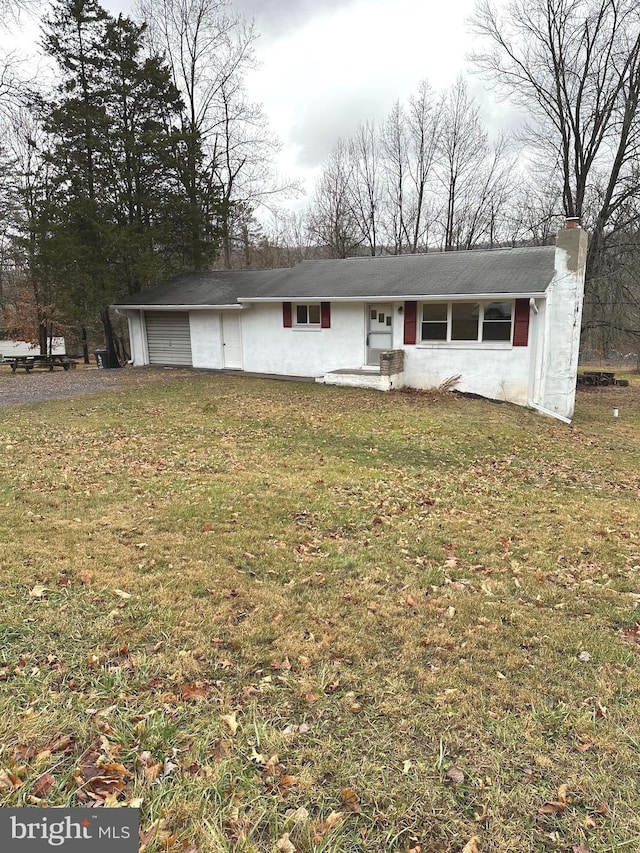 single story home featuring a garage and a front yard