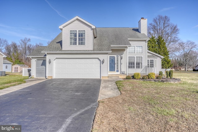 cape cod home featuring a garage and a front yard