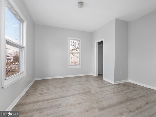 unfurnished room with light wood-type flooring and a wealth of natural light