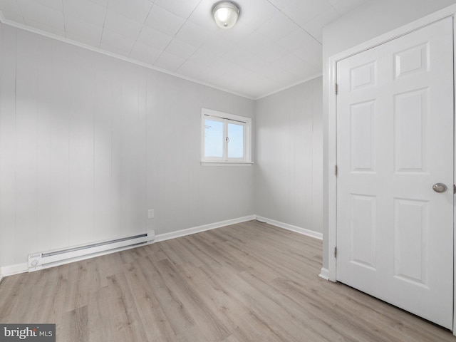 spare room featuring light hardwood / wood-style floors, ornamental molding, and a baseboard radiator