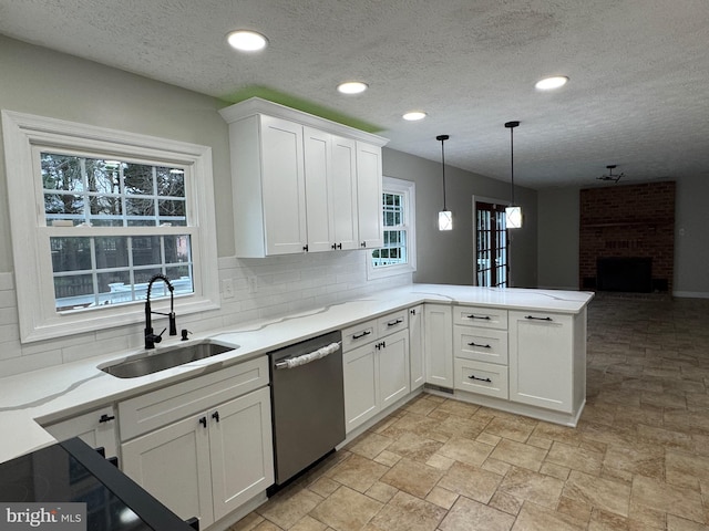 kitchen with kitchen peninsula, stainless steel dishwasher, plenty of natural light, and sink