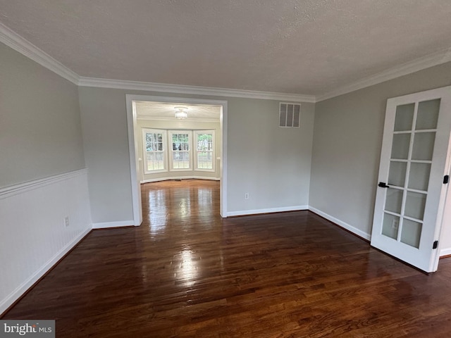 empty room featuring a textured ceiling, dark hardwood / wood-style flooring, and crown molding